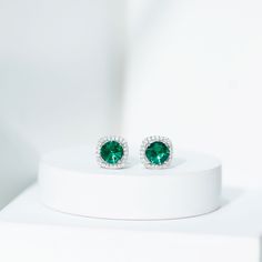 Product Details Experience the enchantment of these captivating Stud Earrings, showcasing a Round Shape Lab Created Emerald at the center, delicately held in a Prong Setting. Surrounding the vibrant created emerald is a dazzling Halo of Moissanite gemstones, adding an extra touch of sparkle. With the inclusion of a Screw Back Closure, these halo earrings ensure a secure fit, providing peace of mind. Whether for a special occasion or everyday wear, these beautiful earrings are guaranteed to elici May Birthstone Diamond Earrings For Wedding, Emerald Halo Jewelry With Round Cut, Halo Emerald Jewelry With Round Cut, Classic Halo Jewelry For May Birthstone, Diamond Halo Jewelry For May Birthstone, Formal May Birthstone Diamond Earrings, May Birthstone Diamond Halo Jewelry, Round Cut Emerald Halo Design Jewelry, Diamond Earrings For Wedding, May Birthstone