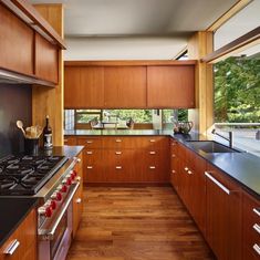 a kitchen with wooden cabinets and black counter tops, along with an island in the middle