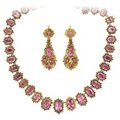 A demi-parure, "parure" meaning "adorn" in French, is a partial set of matching jewelry designed to be worn en suite. This incredible handcrafted pink topaz necklace and earring set is from the early Georgian (ca1750s) era and comprised of a riviera style necklace and a pair of complementary day-to-night earrings. The necklace features 41 graduated and faceted oval-shaped pink topaz stones that look stunning against their 18kt yellow gold, foil-back collet settings. The glittering topaz stones display various shades of pale to light pinks, each link encircled by a brilliant beaded sunburst motif. A secure clasp is incorporated into the design, hidden beneath a pink topaz link, and a hidden hook bail is found behind the central link. The necklace drapes beautifully against the wearer's neck Pink Topaz Jewelry, Rococo Jewelry, Pink Topaz Necklace, Regency Jewelry, Riviera Style, Regency Gown, Fruit Necklace, Iron Jewelry, Georgian Jewelry