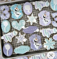 decorated cookies in the shape of snowflakes on a cooling rack with words and symbols