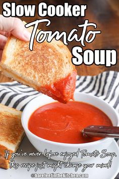 a person dipping some bread into a bowl of tomato soup