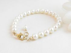 "A classic real freshwater pearl bracelet for newborn, infant, baby, child, little girl, tween or teen. This keepsake bracelet is created with Grade-A 5.5mm round freshwater pearls and a 14K gold-filled oval lobster clasp with a 1/2\" \"Grow with Me\" extender chain. Arrives packaged in my signature high-quality reusable canvas gift bag. Beautiful and ready for gift giving. S I Z I N G . G U I D E The bracelet should be 3/4\" larger than her snug wrist measurement. If you are unable to measure, Classic Adjustable Hypoallergenic Pearl Bracelet, Adjustable Classic Pearl Bracelet For Anniversary, Classic Adjustable Pearl Bracelet For Anniversary, Elegant Pearl Jewelry For Baptism, Elegant Adjustable Pearl Bracelet For Baptism, Elegant Pearl Rosary Bracelet For Baptism, Classic Adjustable Jewelry For First Communion, Classic Beaded Bracelet With Extender As Gift, Elegant Pearl White Jewelry For Baptism