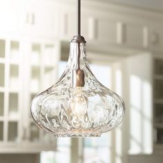 a clear glass light fixture hanging from a ceiling