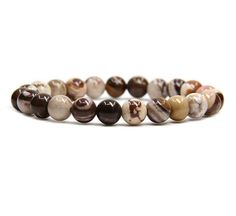 a bracelet made out of beads with brown and white marbles on the inside of it