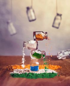 an assortment of spices and condiments being poured into glass bottles on a wooden table