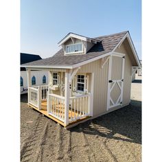 a small white house with a porch and windows