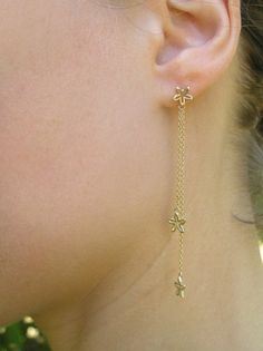 14k gold dangle flowers earrings. Beautiful, sweet and dainty solid gold earrings, with delicate flowers dangling from gold chains. App. 7 cm long. Made of 14k gold with a shiny finish. Also available, gold flower studs, here: http://www.etsy.com/listing/74272111/ A matching necklace: https://www.etsy.com/listing/487540199 To get back to my shop click here: http://www.etsy.com/shop/DaliaShamirJewelry?ref=si_shop Long Chain Earrings Gold, Beautiful Diamond Earrings, Unique Gold Jewelry Designs, Gold Flower Earrings, Bridal Chura, Dainty Gold Earrings, Gold Chain Earrings, Long Chain Earrings, Flowers Earrings