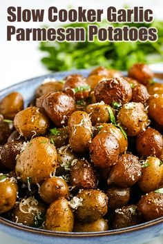 slow cooker garlic parmesan potatoes in a blue bowl with parsley on top