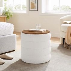 a white ottoman with a wooden top in a living room