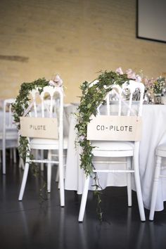 two white chairs sitting next to each other on top of a table