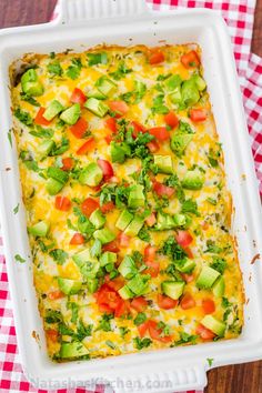 a casserole dish with tomatoes, avocado and other vegetables in it