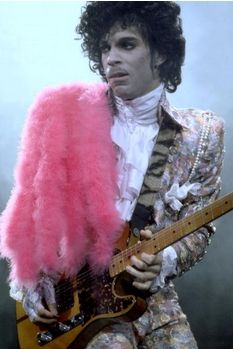 the man is dressed in pink and holding a guitar while wearing a suit with feathers on it