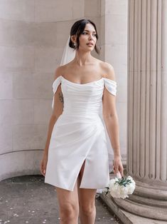 a woman in a white wedding dress is standing on the steps with her hand under her knee