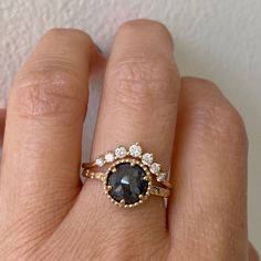 a woman's hand with a ring on it that has an oval shaped blue diamond in the center