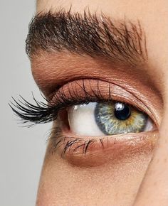 a woman's blue eye with long lashes