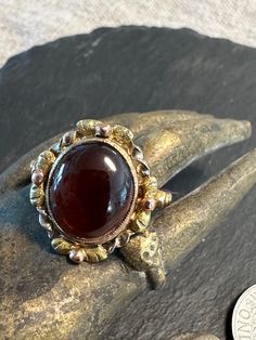 "An early 1900s multi gold genuine red garnet cabochon ring.  Condition I see no problems the photos show the details.  Size 6 1/4, wt.- 3.3 grams, 2/3\" north to south on finger.  A yellow gold ring with rose and green gold hand engraved Fram for the Garnet.  The detailing is crisp and artistic.  circa 1920-30, stamped 10K with Makers mark-DBA-American." Gold Vintage Cabochons, Vintage Oval Gold Cabochons, Elegant Gold Garnet Cabochon Jewelry, Victorian Multi-stone Ruby Ring In Gold, Antique Oval Yellow Gold Ruby Ring, Victorian Ruby Ring With Multi-stone In Gold, Victorian Gold Ruby Ring With Multi-stone, Victorian Yellow Gold Cabochon Ring, Antique Multi-stone Ruby Ring