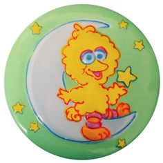 a green and yellow plate with a cartoon character sitting on the moon in front of stars