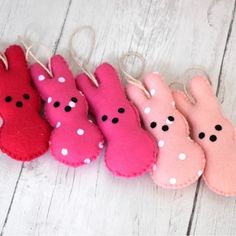 four pink and one red bunny mittens with polka dots on them sitting next to each other