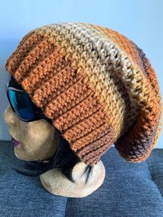 a mannequin head wearing a knitted hat with sunglasses on top of it