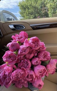 a bouquet of pink flowers sitting in the passenger seat of a car