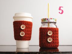 two coffee cups sitting next to each other on top of a table with the number five in front of them