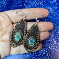 This pair of hand tooled and hand painted leather earrings with beautiful chrysocolla cabochons could become a nice addition to your Boho, hippie, casual, beach, Western clothes. Earrings are made with sterling silver hooks. This piece was MADE TO ORDER, thus in not available. If you would like me to make something for you please contact me for a custom order and we'll discuss the details. I've got plenty of different cabochons in stock, thus I believe we would find something just for you. The p Handmade Blue Leather Earrings, Hand Painted Adjustable Teardrop Jewelry, Bohemian Turquoise Hand Painted Jewelry, Turquoise Bohemian Hand Painted Jewelry, Handmade Leather Turquoise Earrings, Handmade Turquoise Leather Earrings, Handmade Leather Earrings In Turquoise, Artisan Patina Earrings As A Gift, Handmade Southwestern Oval Earrings