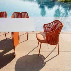 two chairs and a table near a swimming pool