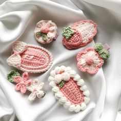 small crocheted items are displayed on a white cloth