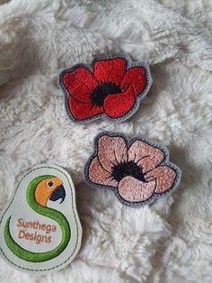 three embroidered patches with flowers on them