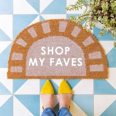 a person standing in front of a door mat that says shop my faves