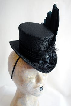 This elegant gothic mini top hat is covered with wonderful black brocade. It is luxuriously decorated with a unique hand-crafted faux raven wing along with curled ostrich spray and black blossoms with crystal details. IMPORTANT NOTE: The fabric seen in the pictures is permanently SOLD OUT! The hat you'll receive will be covered in the brocade seen in the LAST PICTURE. Measurements : height 4 inches( 10 cm ) front to back 9 inches ( 22 cm ) side to side 7.5 inches ( 19 cm ) This mini top hat is f Hat With Flowers, Raven Wings, Mini Top Hat, Elegant Gothic, Fascinator Hat, Mini Top, Edgar Allan, Edgar Allan Poe, Fascinator Hats