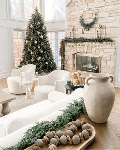 a living room filled with white furniture and a christmas tree in the backround