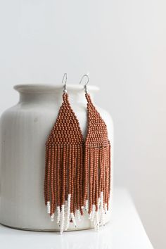 These beaded earrings have been intricately handwoven by artisan women. Bone white beads accent the bottom of these cinnamon brown earrings in a simple yet dramatic way. 4.5" length Locally-sourced beads Handmade in Guatemala Beaded Fringe Earrings, Cinnamon Brown, Brown Earrings, Bone White, Beads Handmade, Beaded Fringe, Fringe Earrings, White Beads, Guatemala