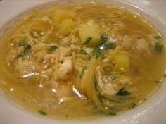 a white plate topped with pasta and chicken soup