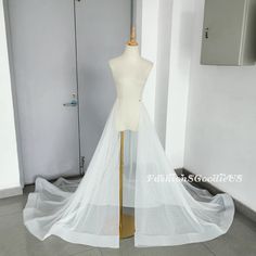 a mannequin is dressed up in a white wedding dress with sheer tulle