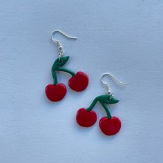 These polymer clay earrings feature red cherries! **Please note that these earrings are handmade and each pair may differ slightly Cute Red Resin Jewelry, Playful Handmade Red Earrings, Clay Cherry, Cherry Clay Earrings, Red Drop Earrings In Polymer Clay, Handmade Trendy Cherry Earrings, Trendy Handmade Cherry Colored Earrings, Trendy Handmade Cherry Earrings, Handmade Cherry Cute Earrings