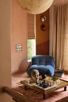 a living room with a blue couch and chess on the coffee table