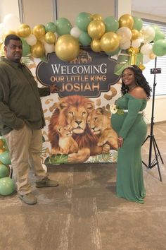 a man and woman standing in front of a welcome sign for their little king joshua baby shower