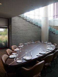 a long table is set up with empty plates and glasses for people to sit at