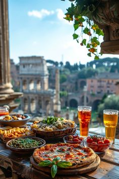 a table with pizzas and drinks on it in front of a view of the roman colossion