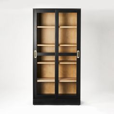 an empty black bookcase with glass doors on the front and bottom shelves, against a white background