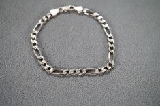 I am offering you this vintage sterling silver bracelet. This Bracelet is done in the classic fancy oblong  figaro shaped link chain. The Bracelet has a lobster claw style clasp, Bracelet measures app. 8 " long, and measures app. 1/4 inch wide. Bracelet is sterling silver and weighs app. 9 grams.   Please review all of my pictures, as these are all a very important part of my listing / description.  Buyer pays shipping and handling. Formal Silver Bracelet With Figaro Chain, Classic Silver Figaro Chain Bracelet, Silver Bracelet With Figaro Chain And Oval Link, Vintage Silver Figaro Chain Jewelry, Vintage Silver Jewelry With Figaro Chain, Clasp Bracelet, Wide Bracelet, Sterling Silver Bracelet, Art Deco Style