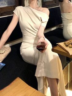 a woman sitting on a bench holding a glass of wine