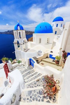 a white and blue building with steps leading up to the water in front of it