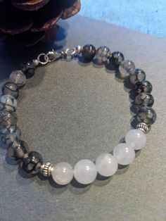 Gray and white Chakra beaded bracelet.  Very comfortable. # 125 Gray Adjustable Bracelets With Faceted Beads, Adjustable Gray Bracelets With Faceted Beads, Adjustable Gray Bracelet With Faceted Beads, White Bracelets With 8mm Adjustable Beads, White Hand-strung Spiritual Bracelets, Handmade Casual White Pearl Bracelet, Casual White Crystal Bracelet, Adjustable White Bracelet With Natural Stones, Casual White Beaded Bracelets With Faceted Beads