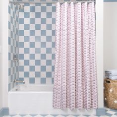 a bathroom with blue and white tiles on the walls, shower curtain, and bathtub