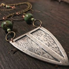 This Sterling Silver, Shield Pendant Measures Approx. 4.5 X 5.5 Cm And Comes On An 8" Antiqued, Brass Chain With A 3" Extender. Green Ceramic & Natural Stone Beads With Subtle, Copper Details. There's A Light Patina To Make The Hand-Texturing Really Pop! 100% Handmade By Me And One Of A Kind! .925 Unique Etched Sterling Silver Necklace, Silver Etched Sterling Silver Necklace, Etched Sterling Silver Necklaces, Unique Silver Etched Necklaces, Antique Silver Etched Sterling Silver Necklace, Artisan Silver Etched Necklace, Artisan Metal Jewelry With Etched Details, Unique Etched Metal Jewelry, Artisan Etched Metal Jewelry