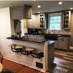 a kitchen with wooden floors and gray cabinets