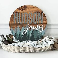 a wooden sign sitting on top of a white floor next to a pile of blankets