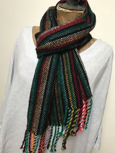 I love this gorgeous striking scarf It is so unusual including a myriad of colours and was an absolute joy to weave.  I have Handwoven it here in my home in North Wales on one of my rigid heddle looms in a 'tabby' weave using a range of colours from black to white with reds, greens, yellows and blues in the warp and then black in the weft which makes all those other colours stand out and 'sing'. I love it. I have already machine washed this scarf as part of the 'finishing' process and any future Traditional Multicolor Winter Scarf, Traditional Multicolor Winter Scarves, Traditional Multicolor Scarves For Winter, Bohemian Multicolor Scarves For Winter, Handmade Multicolor Winter Scarves, Bohemian Multicolor Handwoven Shawl, Traditional Multicolor Scarves, Multicolor Bohemian Shawl As A Gift, Traditional Multicolor Scarves One Size